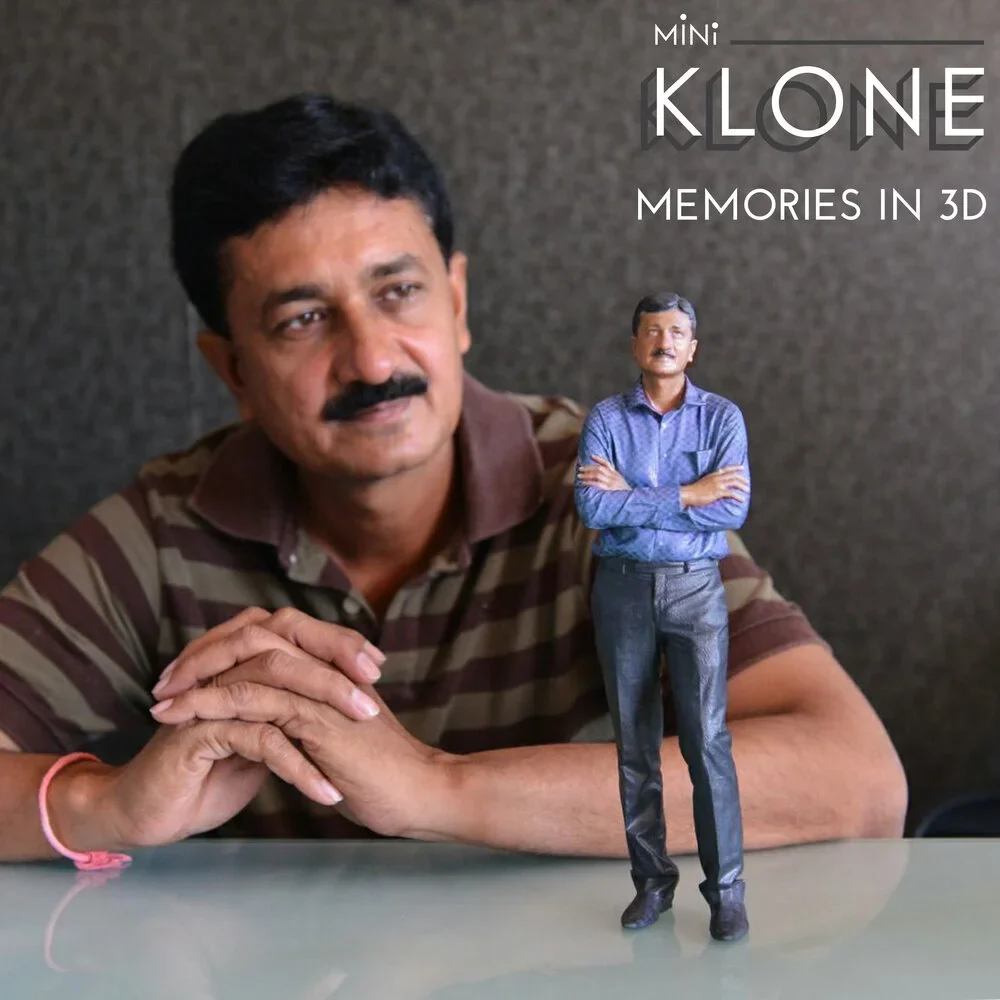 A man sitting beside his own Mini Klone figurine