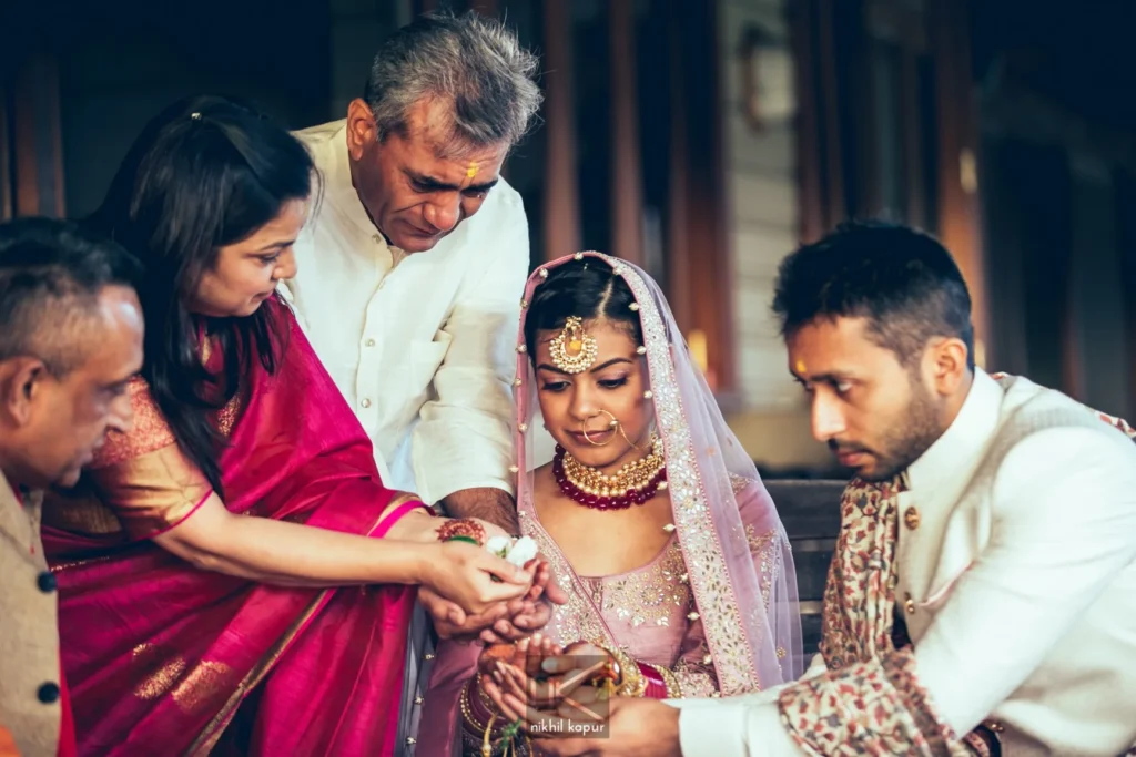 Family hands join the bride and groom during a wedding ritual