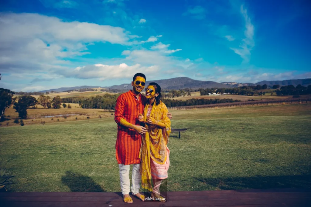 The couple, covered in haldi, on a vineyard lawn